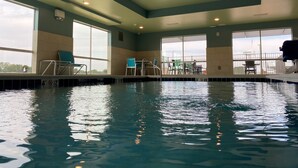An indoor swimming pool with clear water, safety signs, and chairs around the pool. - Holiday Inn Express & Suites Union City by IHG (Union City)