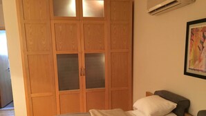 A bedroom with a bed, a wardrobe with frosted glass doors, and a framed picture on the wall. - Luxury Villa, Scandinavian style,in Golf Solimanya (Giza)