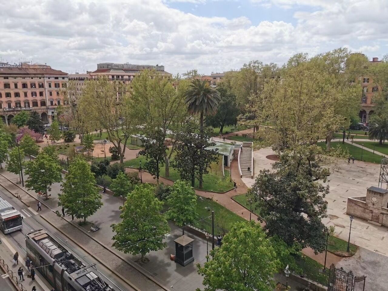 Een park met paden, bomen en een tramlijn.
