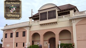 Un edificio con una amplia entrada en arco, un balcón y un cartel que dice