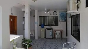 Un espacio habitable compacto con kitchenette, comedor y una pequeña zona de estar.
