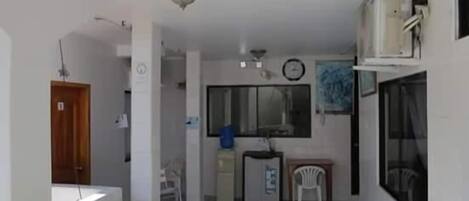 Un espacio habitable compacto con kitchenette, comedor y una pequeña zona de estar.
