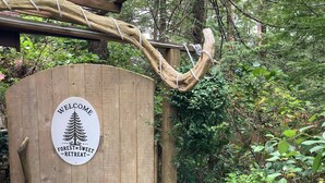 Une porte en bois sur laquelle est apposée une pancarte indiquant : « BIENVENUE À FOREST SWET RETREAT ».