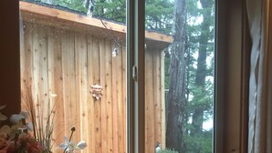 Une table en bois sur laquelle se trouvent une bougie allumée, une tasse et un petit bol.