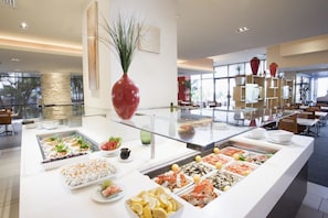 A buffet with various food items and a large vase.
