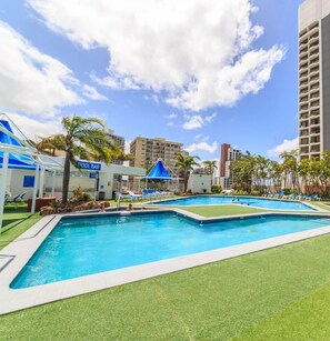 A swimming pool area with lounge chairs and a pool bar. - L5 Surfers Paradise Apartment (Surfers Paradise)