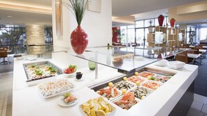 Un bufé con diversos alimentos y un jarrón grande.