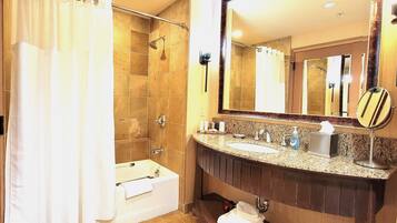 A bathroom with a bathtub, a sink, a mirror, and a shower.