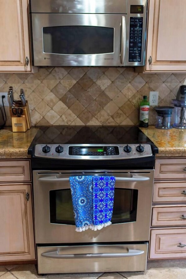 A kitchen with a stainless steel oven, microwave, and a digital clock. - Steps to Downtown Shopping~Views~Pike's Peak Villa~ Perfect Location (Colorado Springs)