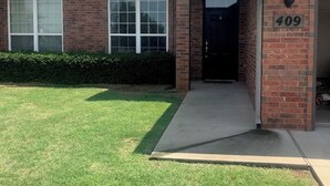 A two-story brick building with a number 409 sign, large windows, and a well-maintained lawn. - Cute, cozy, close duplex. (Stillwater)