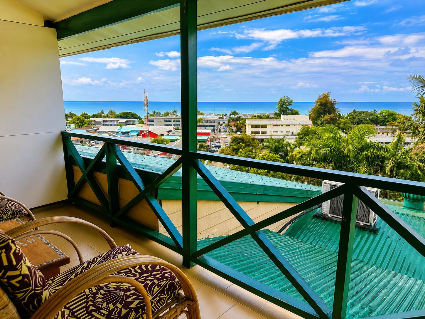 A balcony with a view of the ocean and buildings.