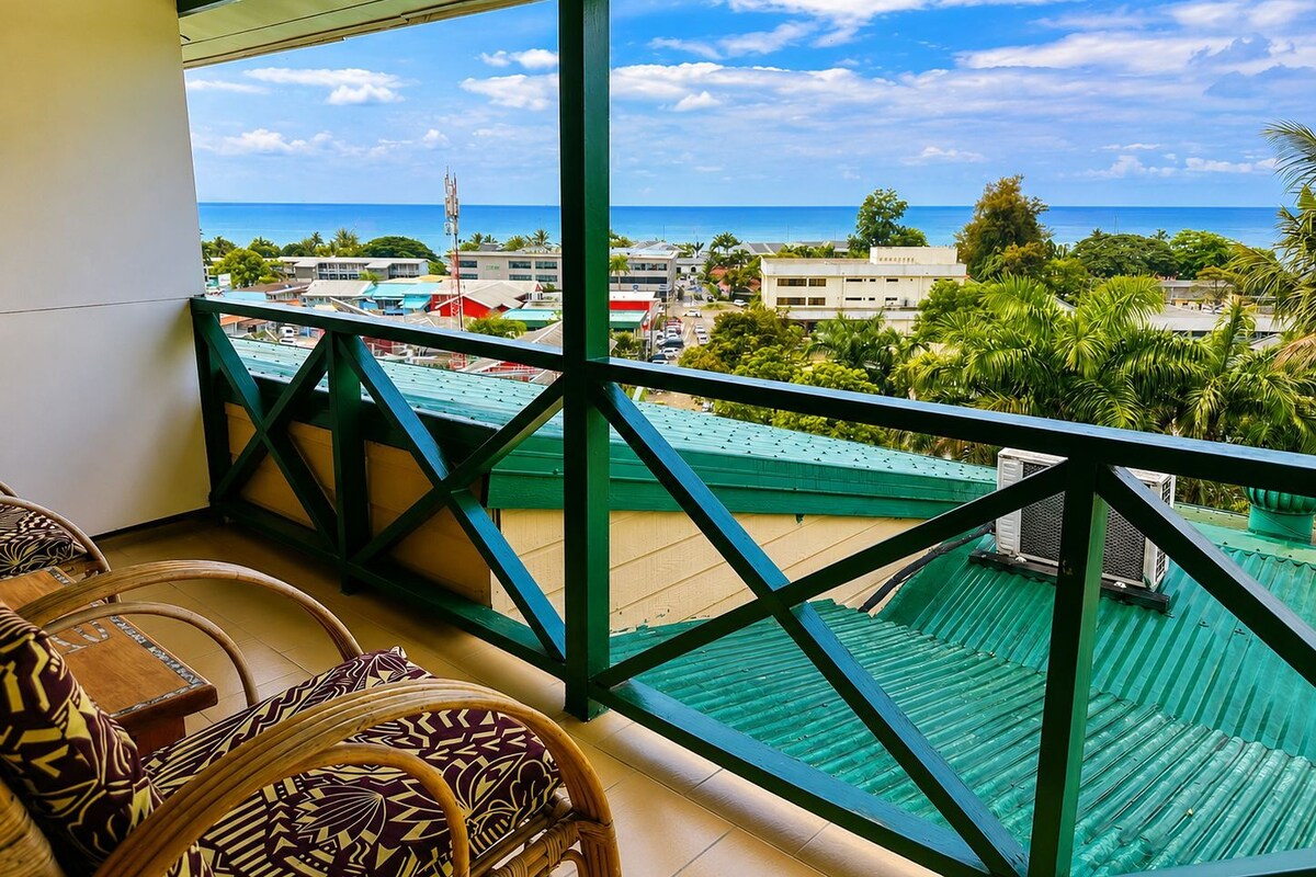 A balcony with a view of the ocean and buildings.