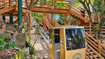 A wooden staircase with a small yellow kiosk labeled 'King Solomon Hotel' in a garden setting.