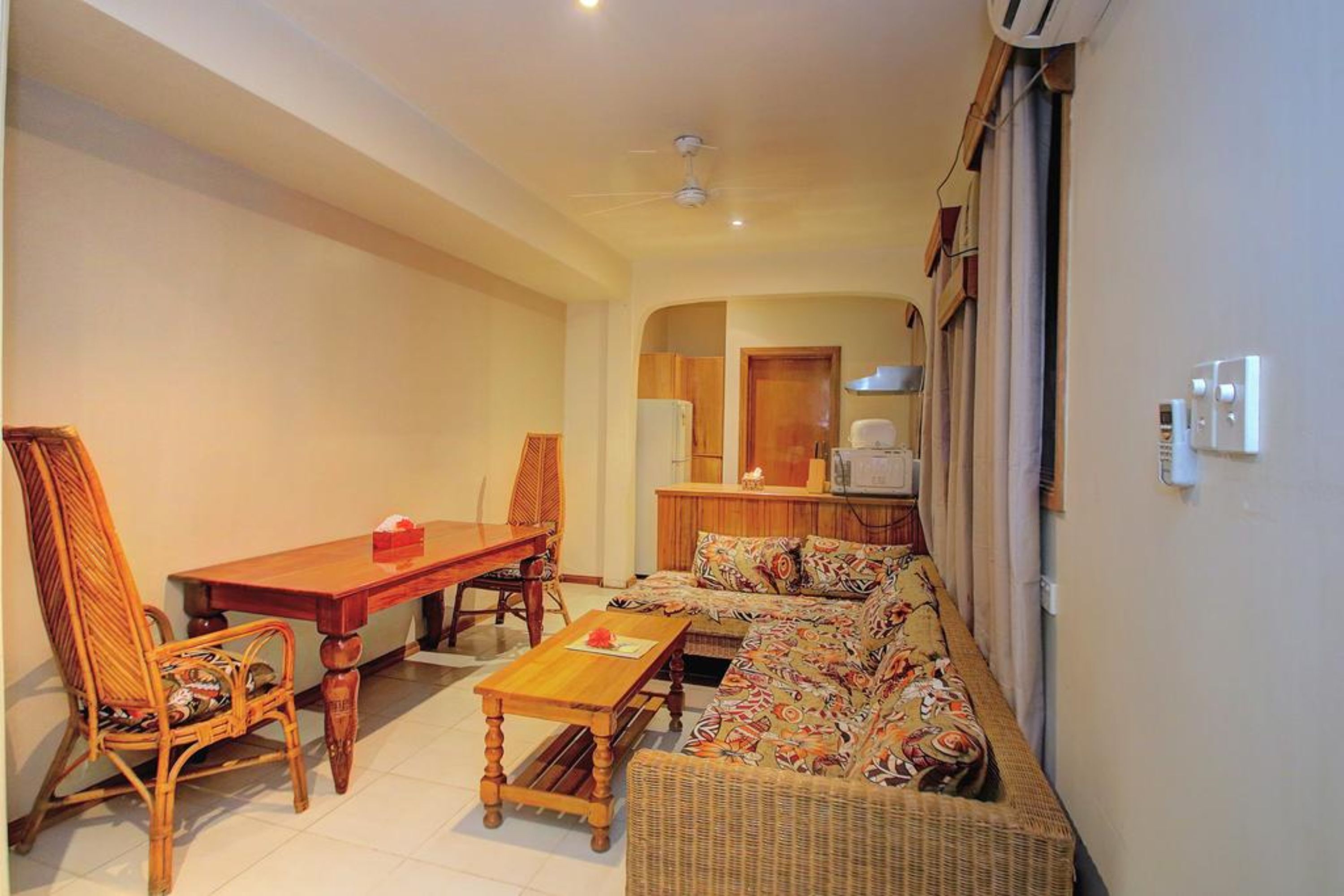 A compact living room with a sofa, a dining table, and chairs.