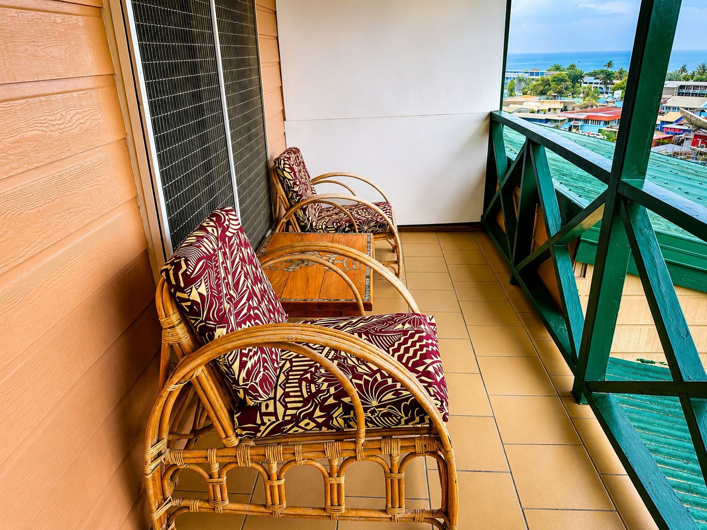 A balcony with wicker furniture and a view of the sea.