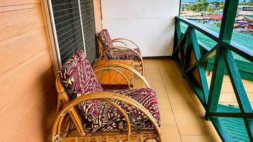 A balcony with wicker furniture and a view of the sea.
