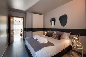 Une chambre d’hôtel moderne avec un grand lit, une table de chevet avec une lampe et une vue sur le balcon.