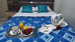 A hotel room with a bed, a tray with breakfast, and a towel. - Hotel Brickell (Lima)