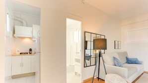 Ein modernes Wohnzimmer mit einem weißen Sofa, einer Stehlampe und einem Couchtisch.