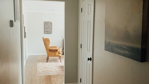 A hallway with wooden flooring, a white door, and a framed picture on the wall. - CritzerShop - route 151- walk to the Brewey! (Afton)