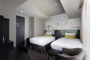 A hotel room with two beds, a desk, and a chair.