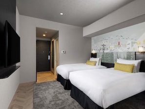 A hotel room with two beds, a flat-screen TV, a cityscape mural, and a wooden floor.