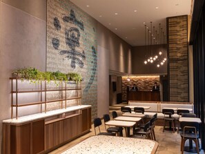 A modern interior with a reception desk, seating area, and a wall with a pattern. - ibis Styles Tokyo Ginza East (Tokyo)