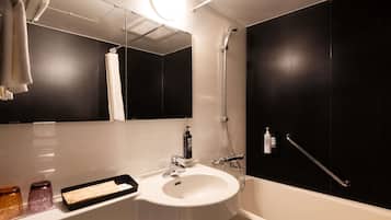 A modern bathroom with a white sink, a mirror, a handheld showerhead, and a towel rack.