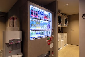 Een automaat met verschillende drankjes en een waterkraan.