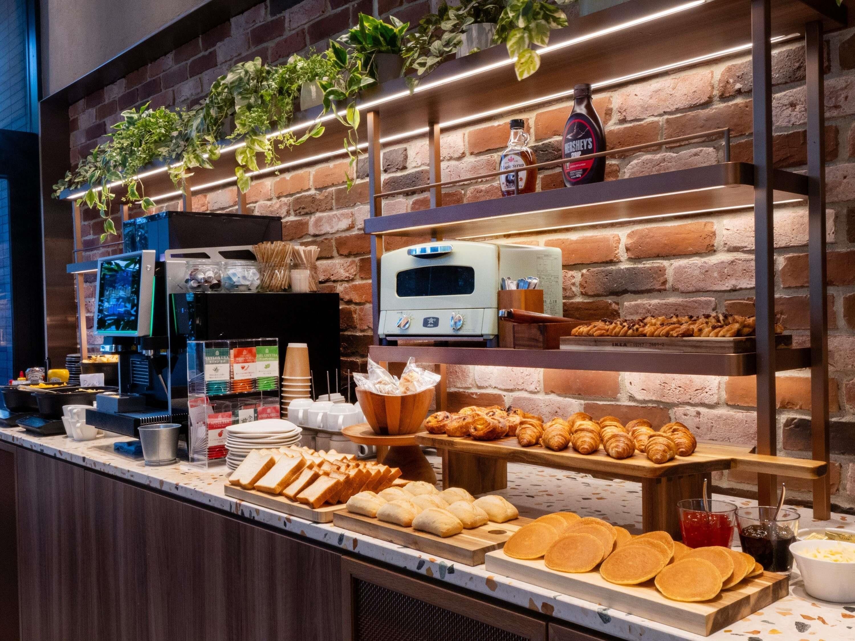 A breakfast buffet with pastries, bread, and beverages.