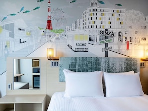 Een hotelkamer met een bed, nachtkastje, lamp en een muurschildering met bezienswaardigheden van Tokio.