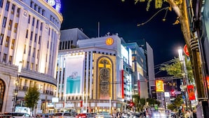 A nighttime cityscape with a prominent building featuring a large clock tower and illuminated signage. - ibis Styles Tokyo Ginza East (Tokyo)