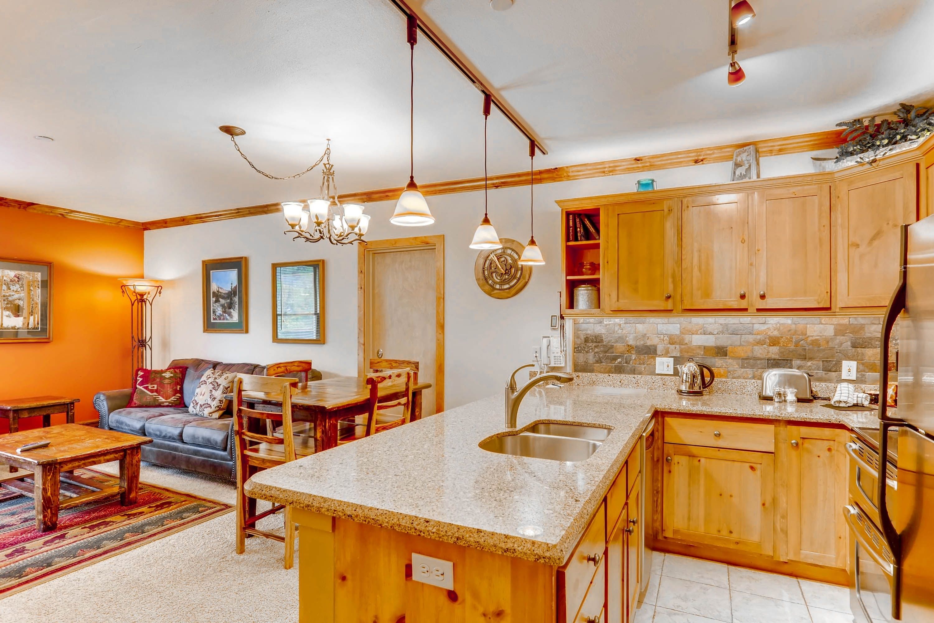 A compact kitchen with wooden cabinets, a granite countertop, and a built-in sink.