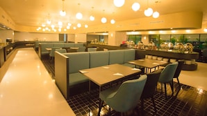 Un restaurant moderne avec des banquettes, des tables et des lampes sphériques suspendues au plafond.
