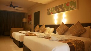 Habitación de hotel con dos camas, ventilador de techo, aire acondicionado, lámpara y obra de arte en la pared.