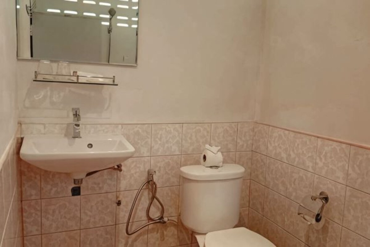 A bathroom with a sink, toilet, and mirror.