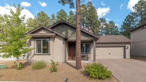 A single-story house with a garage, a front porch, and a small front yard with landscaping. - Beautiful home! Central AC! 5 mins to Downtown! Great setting! 20% Monthly Disc! (Flagstaff)
