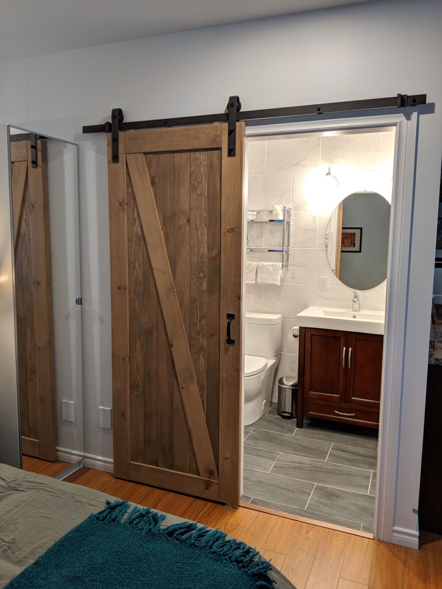 A bathroom with a toilet, sink, and mirror.