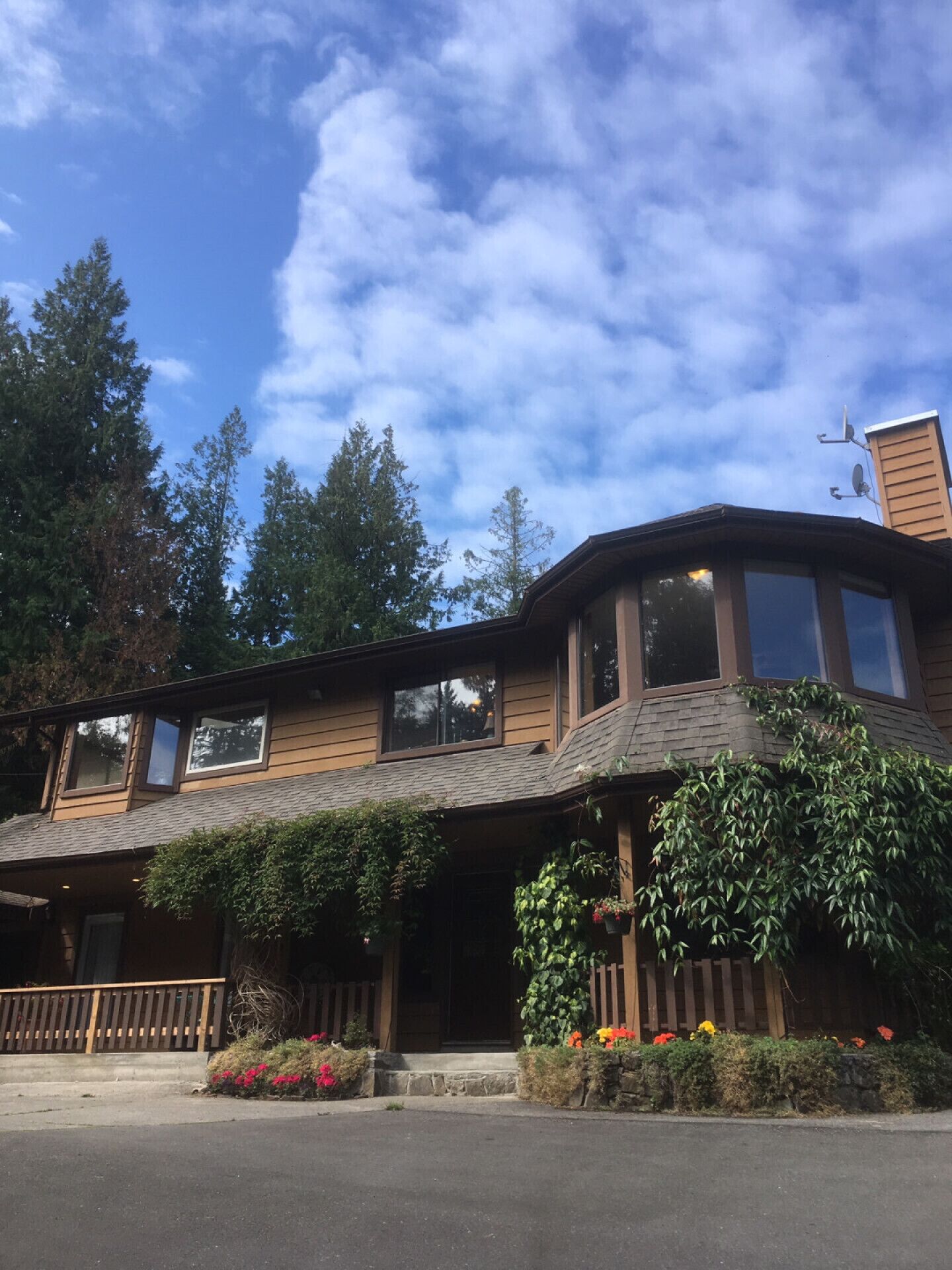 A two-story wooden building with large windows and a sloped roof.