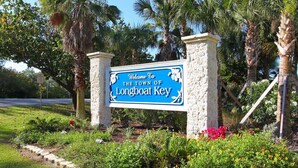 A welcome sign for the town of Longboat Key, surrounded by palm trees and flowers. - End of summer sale  Take a peek awesome reviews 50 feet from  sand (Longboat Key)