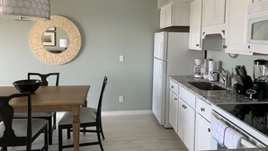 A modern kitchen with white cabinets, a marble countertop, and a built-in oven. - End of summer sale  Take a peek awesome reviews 50 feet from  sand (Longboat Key)