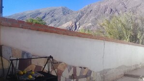 Una parrilla con limones y un muro de piedra con vista a la montaña.