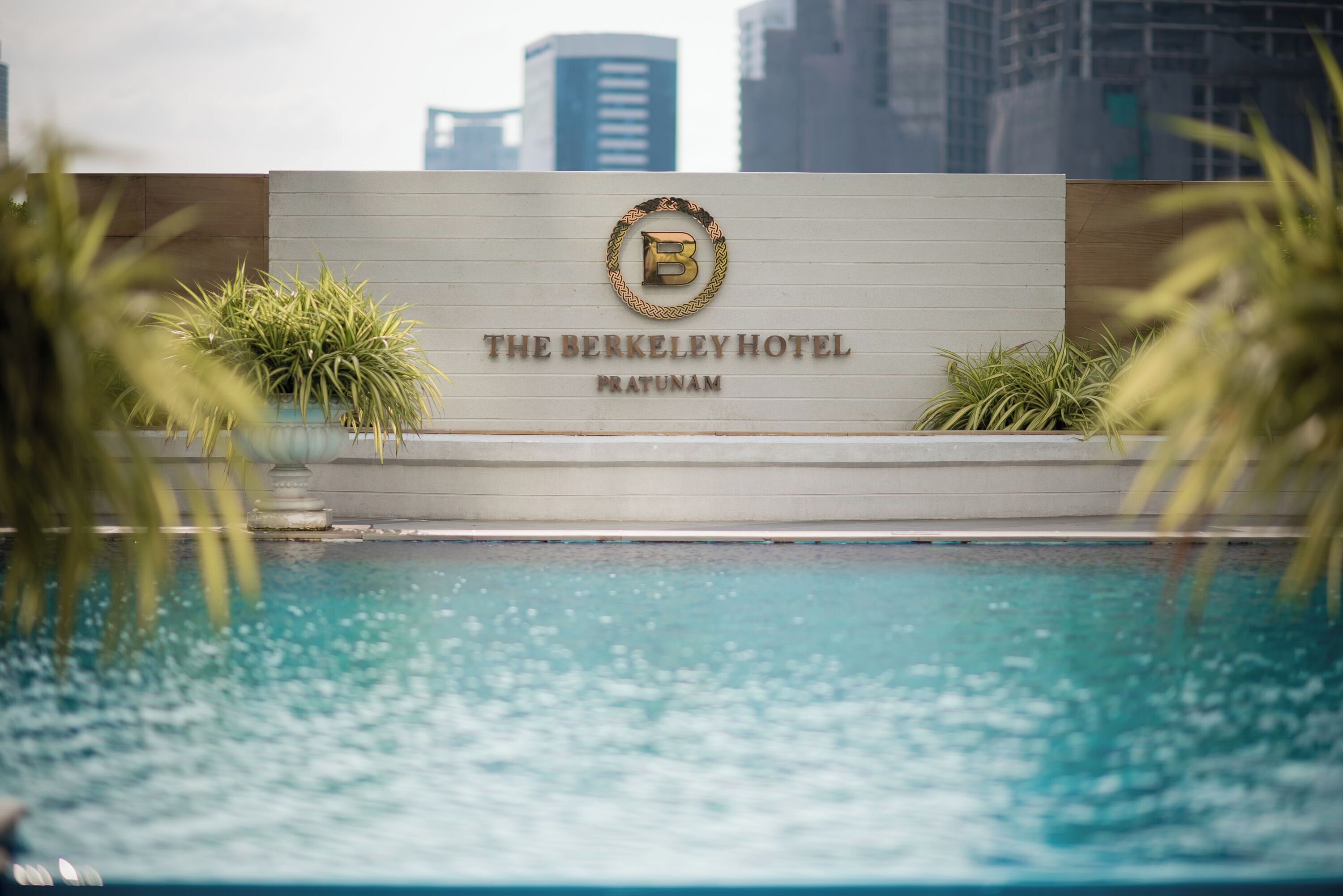Placa de hotel com piscina em primeiro plano.