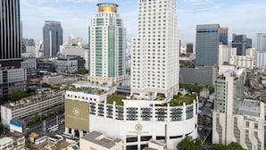 Een hoog hotel met een opvallende gouden koepel, omringd door moderne wolkenkrabbers.