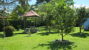 A gazebo with a tiled roof, surrounded by a well-maintained lawn and various trees. - apartamento completo a 2 minutos ruta 32 (Jiménez)