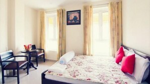 A hotel room with a bed, a desk, two chairs, and a window with curtains. - My House Hotel Vung Tau (Ho Chi Minh City)
