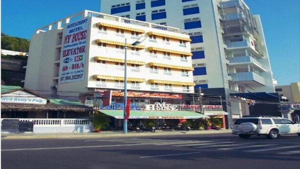 A multi-story hotel with a sign advertising a restaurant and an elevator. - My House Hotel Vung Tau (Ho Chi Minh City)