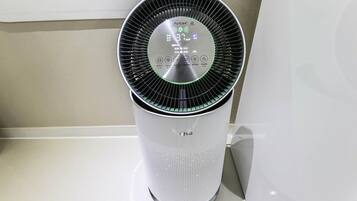 A white air purifier with a digital display and control panel.