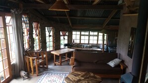 A rustic interior with a wooden table, sofa, and a fireplace. - Bushwhacked Barberton (Barberton)