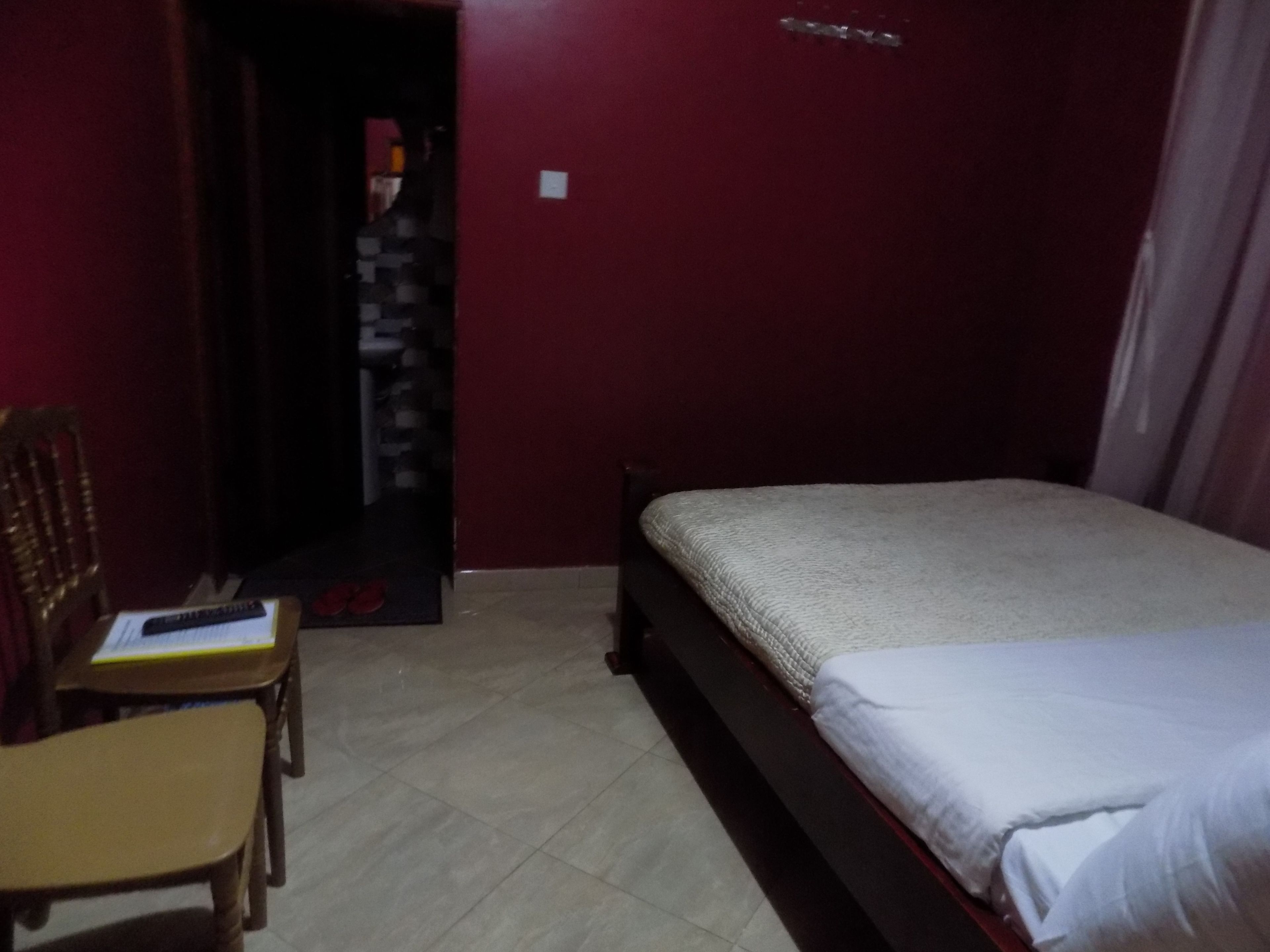 A bedroom with a bed, a chair, and a desk.